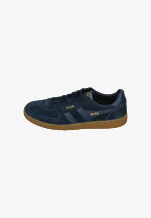 Navy suede sneaker with brown rubber sole. Features a lace-up design, gold accents, and a logo on the side. Smooth texture, rounded shape.