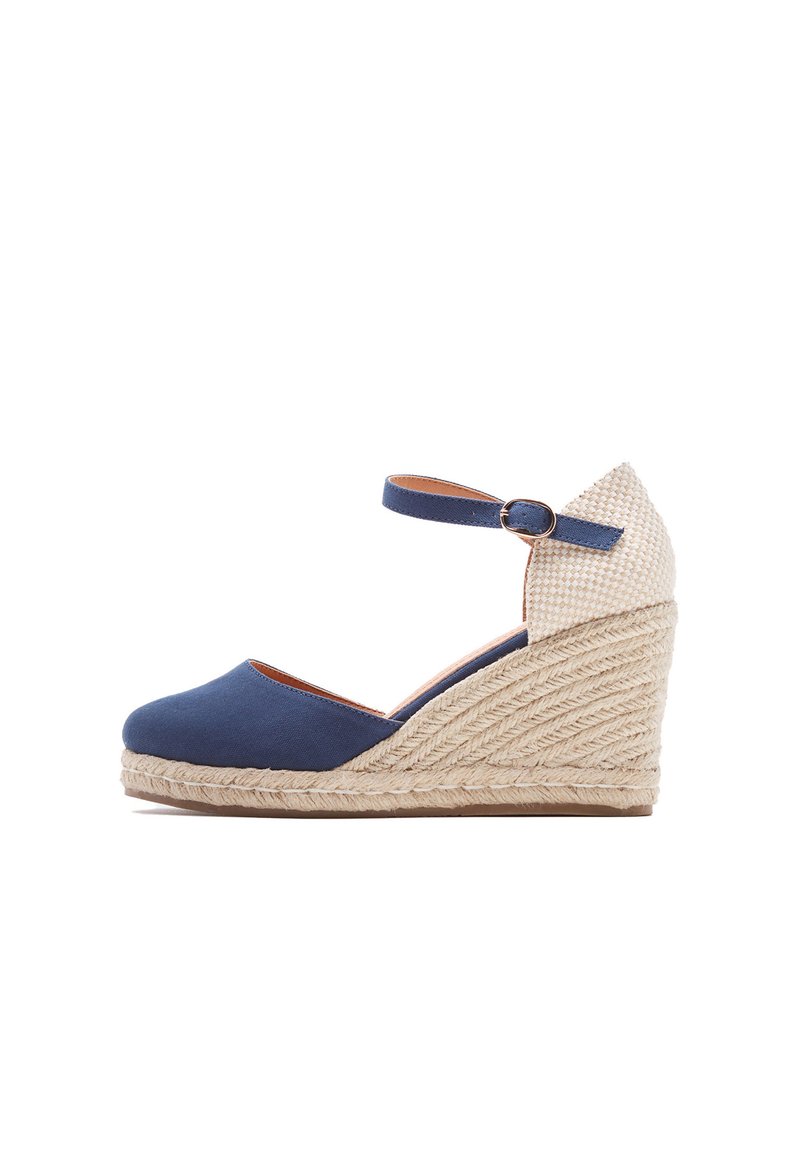 Scarpe con zeppa in tela blu navy, con tacco in juta intrecciata e cinturino alla caviglia. Il tacco presenta un accento in tessuto beige testurizzato.