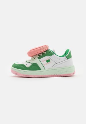 Lavtop sneaker i hvid, grøn og pink med en aftagelig pink pung fastgjort over snørebåndene.