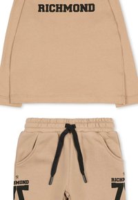 Completo sportivo color marrone chiaro composto da una maglia a maniche lunghe e pantaloni. La maglia presenta la scritta "RICHMOND" in caratteri neri e bold; i pantaloni hanno una cintura elastica e tasche.