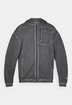 Chaqueta con capucha de color gris oscuro que cuenta con un cierre frontal, puños elásticos, un gran bolsillo delantero y el logotipo de "Champion" en la parte superior izquierda.