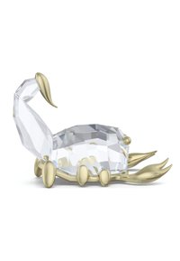 Kristallskorpionfigur med geometriska facetter, en genomskinlig kropp och ben och svans i guldton, med släta och reflekterande ytor.