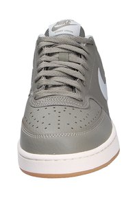 Las zapatillas Nike Court Vision en cuero gris cuentan con una caja de dedos perforada, cordones grises, un Swoosh blanco y una suela de goma.