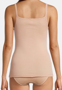 Light beige tank top with thin straps, smooth texture, and a fitted design, paired with matching beige shorts, viewed from the back.