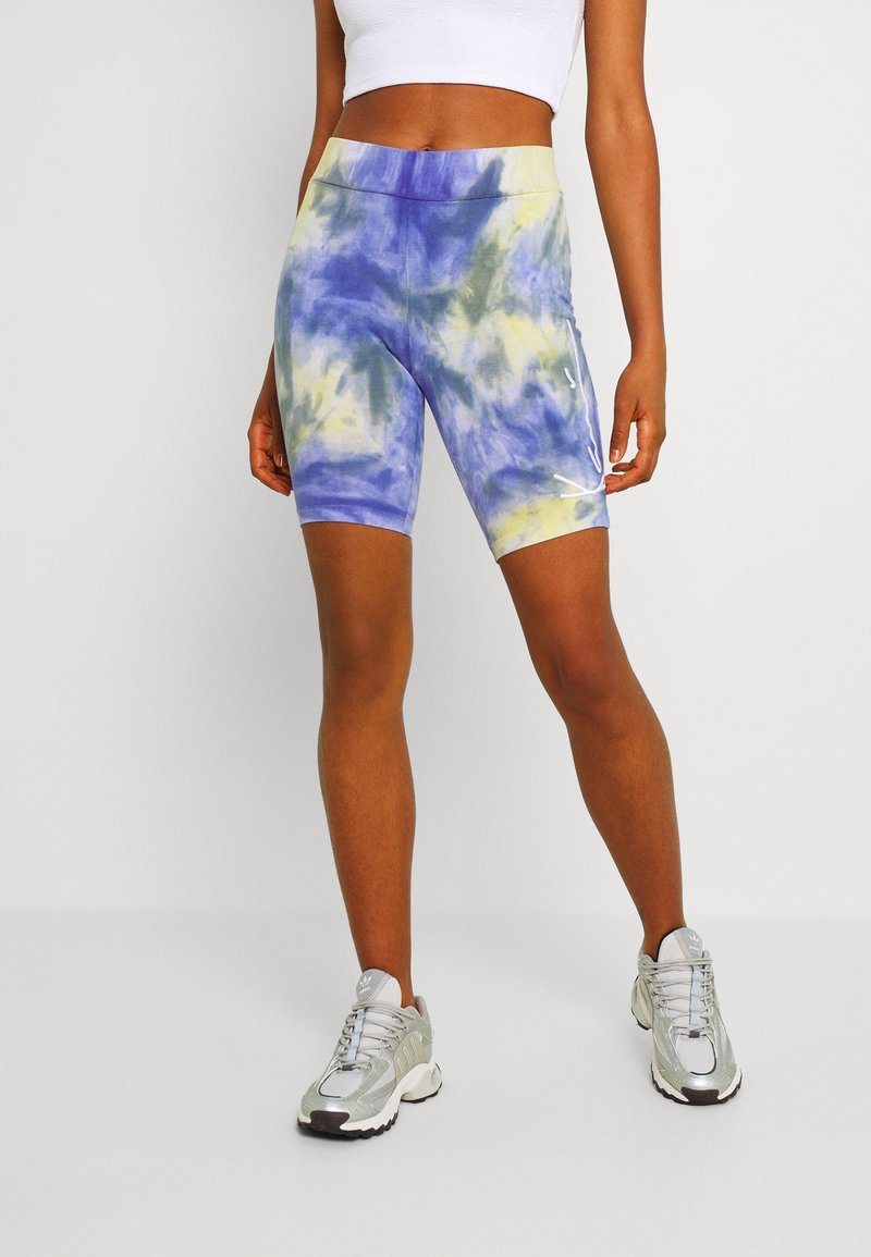 High-waisted bike shorts in a tie-dye pattern of blue, yellow, and green. Features a smooth fabric and side logo detail.