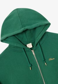 Felpa verde con zip realizzata in misto cotone, dotata di cappuccio con coulisse, zip in metallo e logo ricamato dorato. Tessuto morbido, design casual.