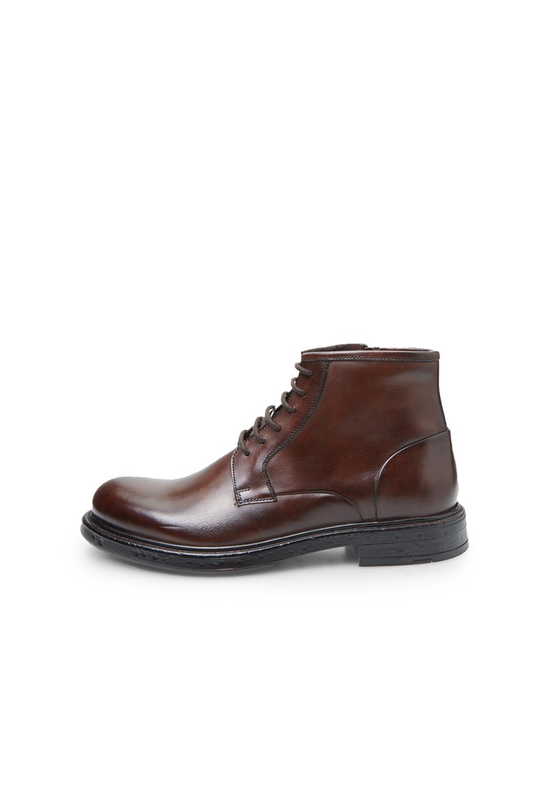 Bota de tobillo de cuero marrón con un acabado suave, cordones en la parte frontal, punta redonda y suela de goma negra. Detalles de costura simples a lo largo de los bordes.