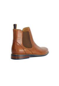 Brown leather Chelsea boot with elastic side panels, rounded toe, and a low stacked heel. Features a leather upper and contrast stitching.