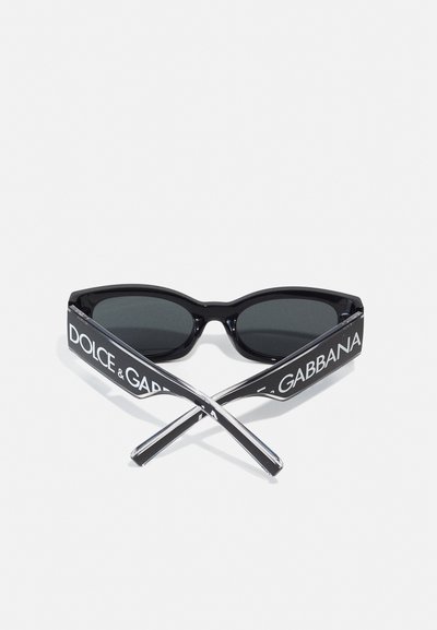 Óculos de sol pretos com lentes retangulares, armações brilhantes e hastes grossas com o nome da marca "DOLCE & GABBANA" em letras brancas.