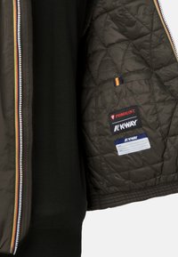 Giacca trapuntata verde scuro con zip e accento a righe multicolori. Etichette per Primaloft e K-way all'interno. Texture liscia.