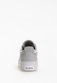 Sneaker grigia con una tomaia in tessuto decorativo a motivi. Presenta una punta tonda, colletto imbottito e una suola in gomma bianca con il marchio "GUESS".