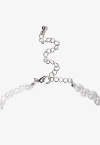 Collana in argento con perle bianche, dotata di chiusura a lobo e catena di estensione per una lunghezza regolabile.