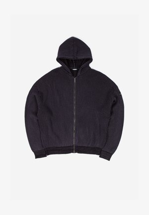Kapucnis, sötétszürke cipzáros pulóver, függőleges bordás textúrával, oldalsó zsebekkel és laza szabással. A cipzár az elején húzódik le.