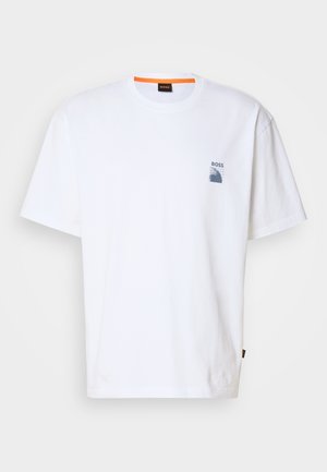Camiseta de algodón blanca con un pequeño logo azul y un diseño gráfico en el lado izquierdo del pecho; corte relajado con un cuello redondo clásico.
