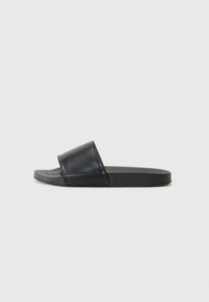 Black leather slide sandal with a wide strap, flat sole, and textured rubber bottom. Simple design focuses on comfort and functionality.