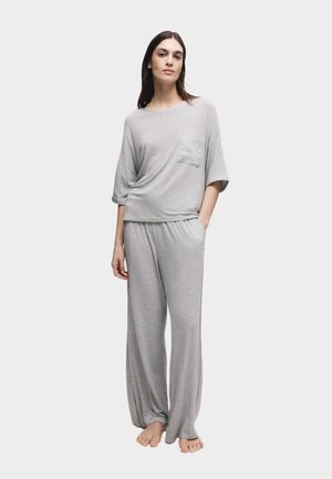 Gråt lounge-sæt lavet af blødt stof med en afslappet kortærmet top med en lomme og løstsiddende bukser.