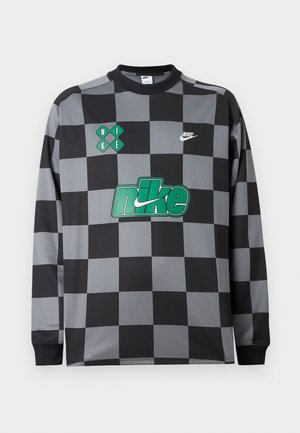 Ilgas rankovėmis Nike marškinėliai su juodai pilku šachmatų paveikslu, žalia Nike logotipu ant krūtinės, mažais baltais ir žaliais prekės ženklo akcentais priekyje.