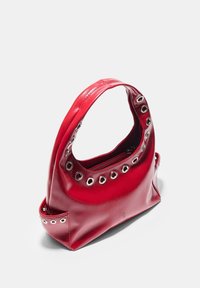 Borsa a mano in pelle rossa con finitura lucida, caratterizzata da occhielli metallici lungo il bordo superiore, un manico singolo arrotondato e un compartimento con chiusura lampo.