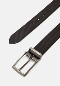 Schwarzer gewebter Gürtel aus strukturiertem Material, mit einer rechteckigen Metallschnalle in silberner Farbe und mehreren Einstelllöchern.