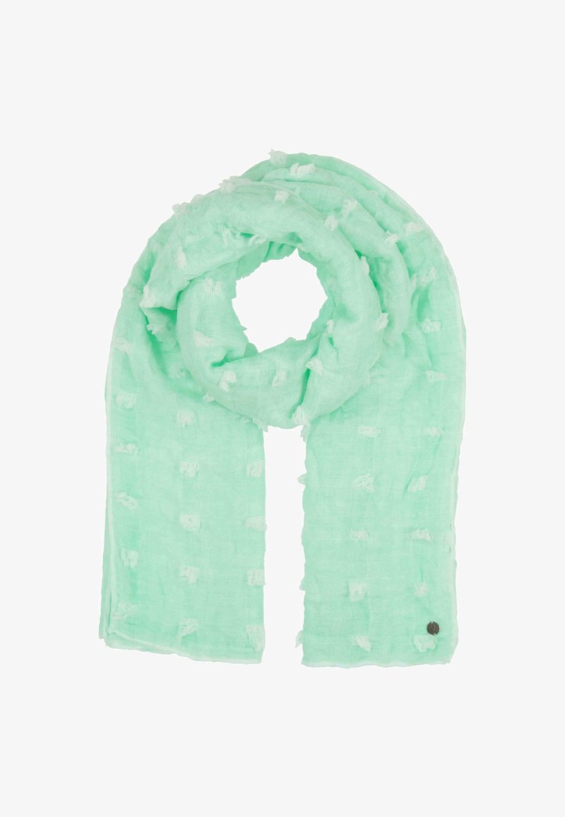 Mėtų žalios spalvos skara, pagaminta iš lengvo audinio, turinti tekstūrinį raštą su švelniais pūkais ir mažu apvaliu akcentiniu ženklu.