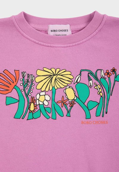 Sweat-shirt violet pour enfants avec une illustration florale colorée sur la poitrine et une étiquette de la marque "BOBO CHOSES" à l'intérieur du col.