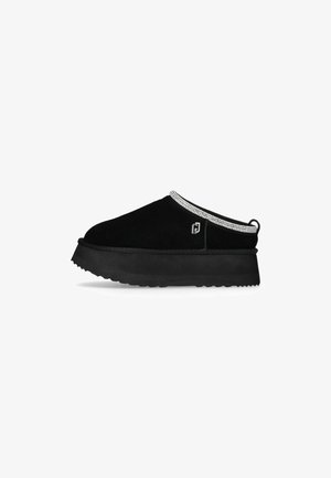 Scarpe slip-on in suede nero con una suola in gomma spessa, decorate con una rifinitura di strass lungo il colletto e un piccolo logo.