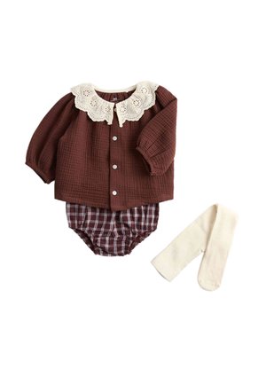 Bruin babyshirtje met lange mouwen en een witte kanten kraag, bijpassende geruite luierbroek en aparte crème-kleurige maillot platgelegd op een witte achtergrond.