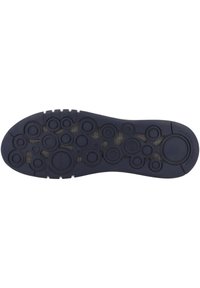 Suola nera in gomma con texture circolari e varie indentazioni. Presenta un bordo liscio con una leggera curvatura sulla punta e sul tallone.