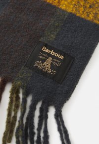 Wollen sjaal met franjes in een bruin, groen, grijs en geel ruitpatroon, voorzien van een zwart Barbour-label met een vuurtorenlogo.