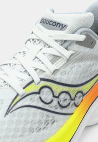 Lightweight Saucony running shoe in white mesh with gray accents. Features a curved multicolored design in yellow and orange on the sole.