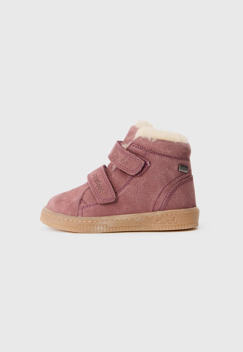 Roze suède enkellaars met twee klittenbandstraps, gevoerd met crèmekleurige bont, en een rubberen zool met een gestructureerd ontwerp.