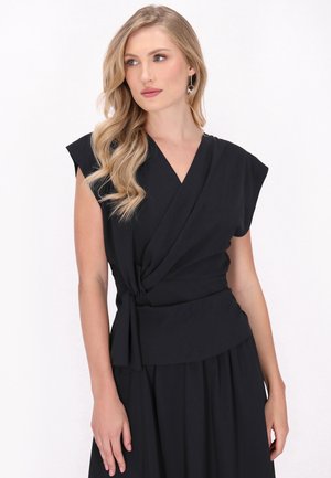 Top avvolgente nero con maniche corte, caratterizzato da un dettaglio annodato in vita. Tessuto morbido e design elegante con scollatura a V.