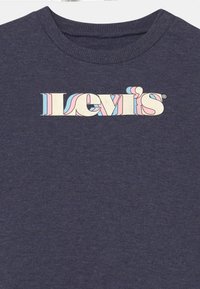 T-shirt bleu marine conçu avec un col rond côtelé, arborant un logo Levi's vintage multicolore en crème, rose et bleu.