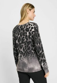 Schwarzer und grauer Leopardenmuster-Pullover mit langen Ärmeln und einem weit geschnittenen Halsausschnitt, aus einem weichen, strukturierten Stoff gefertigt und mit einem allmählichen Farbverlauf.