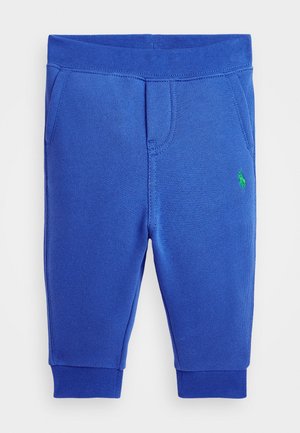 Blaue Kinder-Sweatpants mit elastischem Bund, gerippten Bündchen, Seitentaschen und kleinem grünem Logo am rechten Oberschenkel.
