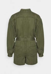 Oliwkowy kombinezon roboczy z długimi rękawami, z paskiem w talii, kieszeniami na piersi i po bokach, wykonany z miękkiej bawełny.