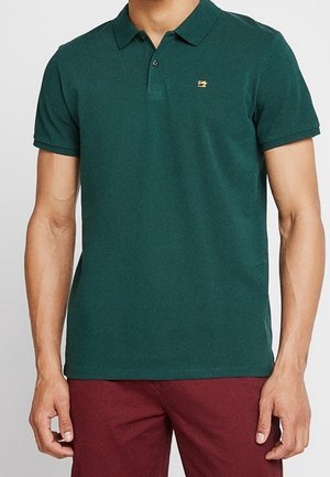 Green polo shirt made of cotton, featuring a collared neckline, short sleeves, and a small embroidered logo on the left chest.
