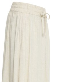 Jupe ample de couleur blanc cassé avec taille élastique froncée et lien en tissu sur le côté, fabriquée en tissu léger texturé.