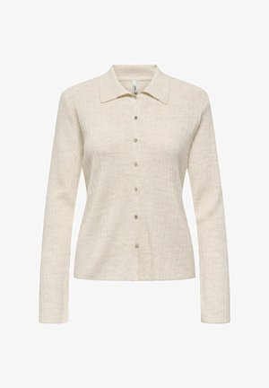 Chemise beige à manches longues avec un col, fermeture à boutons sur le devant, texture en relief verticale et subtile brillance.