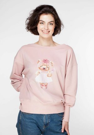 Różowa bluza z oversize'owym krojem, z grafiką misia w sukience. Wysokiej jakości materiał i prążkowane mankiety. Casualowy design.