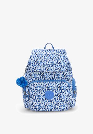 Zaino blu a fantasia con chiusura a patta, presenta una tasca frontale, un portachiavi con pompon e un logo rotondo del brand sul davanti.