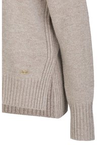 Beige trui van zacht breimateriaal. Beschikt over geribde manchetten en zoom. Inclusief een klein gouden logo detail aan de zijkant.