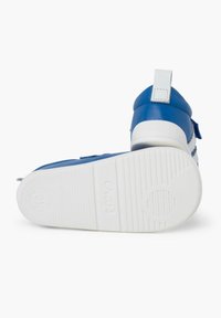 Zapatillas de cuero azul con suela de goma blanca, que cuentan con correas de Velcro y un collar acolchado para mayor comodidad. Suela texturizada para tracción.