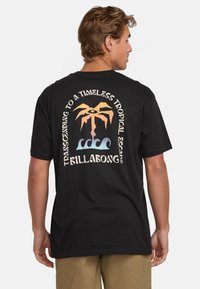 Camiseta negra con un diseño gráfico colorido que incluye una palmera, olas y texto en la parte trasera. Elaborada en algodón y con mangas cortas.