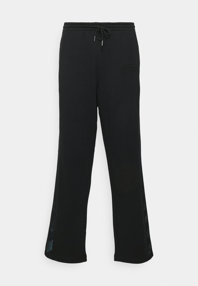 Black sweatpants made from soft fabric, featuring a drawstring waist, flared leg design, and mesh panel accents along the sides.