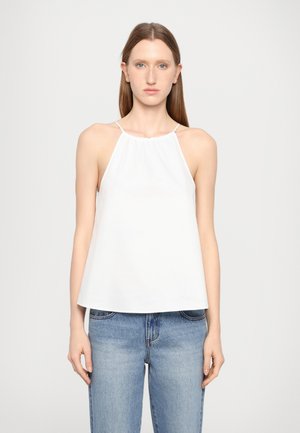 Weißes Top mit Trägern und gerafftem Dekolleté, aus weichem Stoff, lockere Passform und dünne Träger, kombiniert mit hellblauen Jeans.