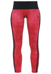 Leggings sportivi rossi con una vita nera, caratterizzati da un motivo strutturato e strisce laterali nere. Realizzati in tessuto elastico e traspirante.
