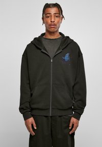 Black zip-up hoodie made from soft fabric. Features a blue butterfly graphic on the chest, front pockets, and ribbed cuffs.