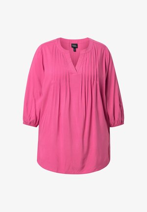 Kirkkaanpunainen pitkähihaisen pusero pliseeratulla etuosalla ja V-pääntiellä, joustavat hihansuut ja väljä istuvuus.