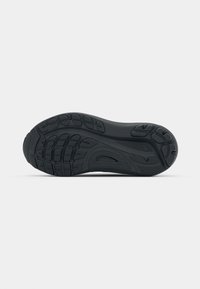 Black rubber sneaker sole with textured grip patterns and varying tread designs. Smooth surface with raised accents for traction.